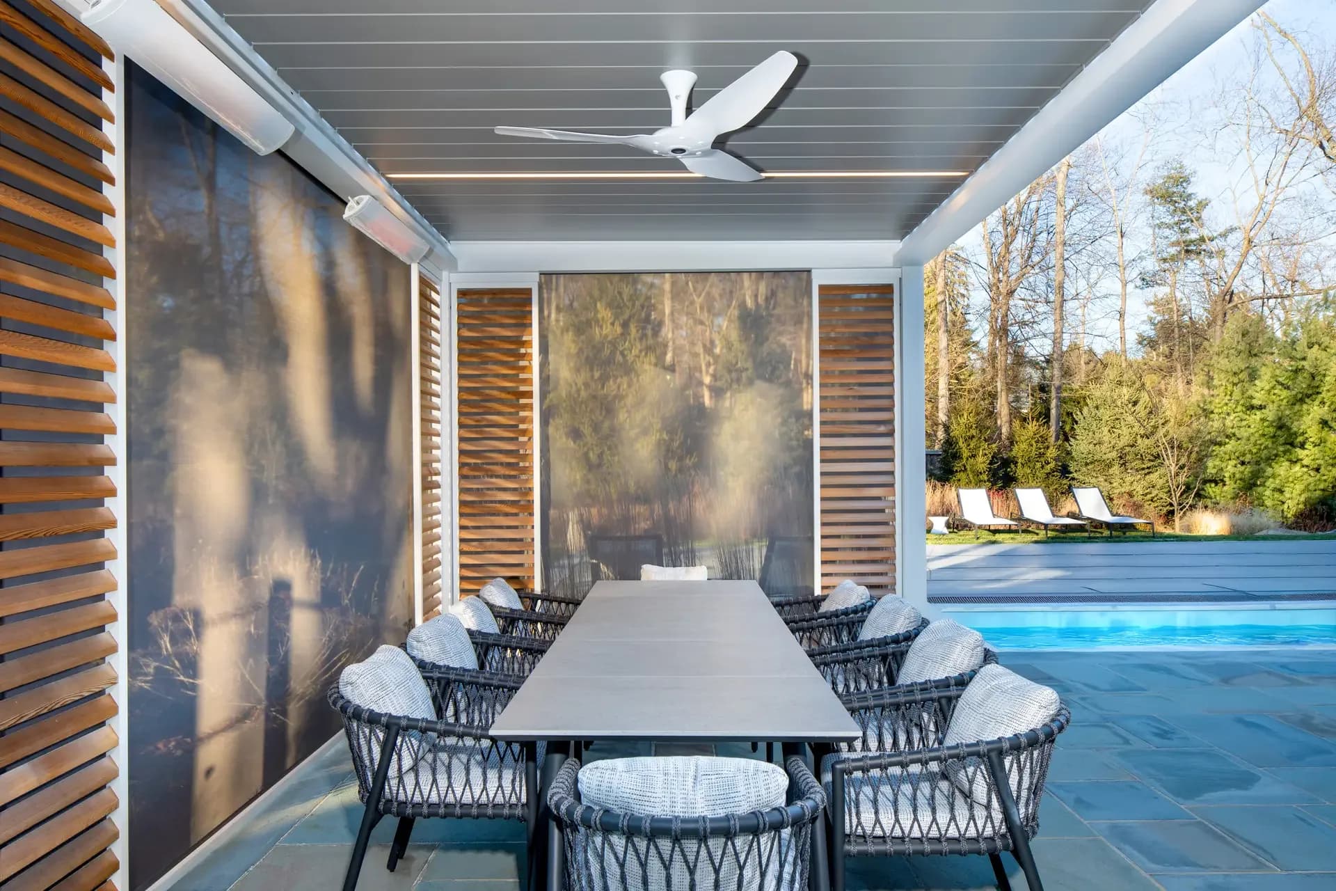 Lowered patio screens around a poolside dining area